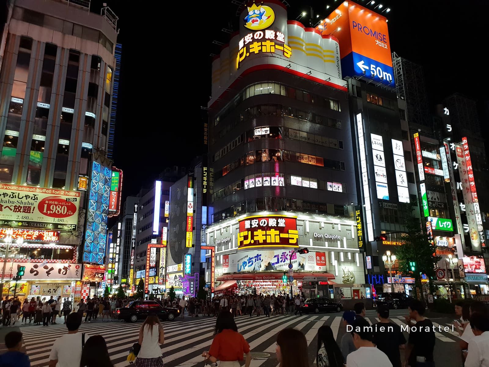 A street lit with neon signs at night